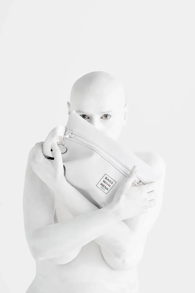 White bodypainted person while holding back