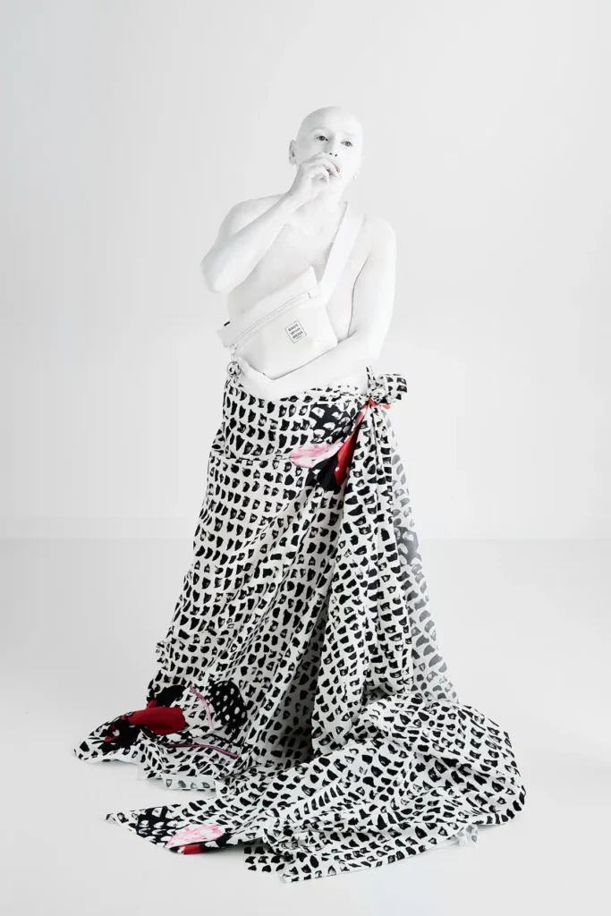White bodypainted person with draped skirt
