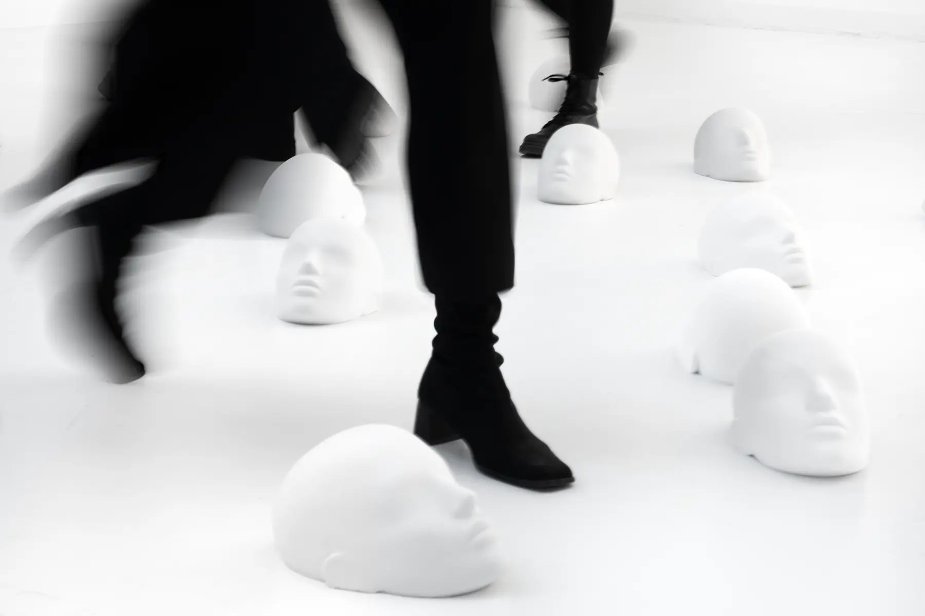 View on sculptures spread around the room laying on the floor with people stepping over it from the project "Femicide" of the Visual Artist Irena Pejčić.