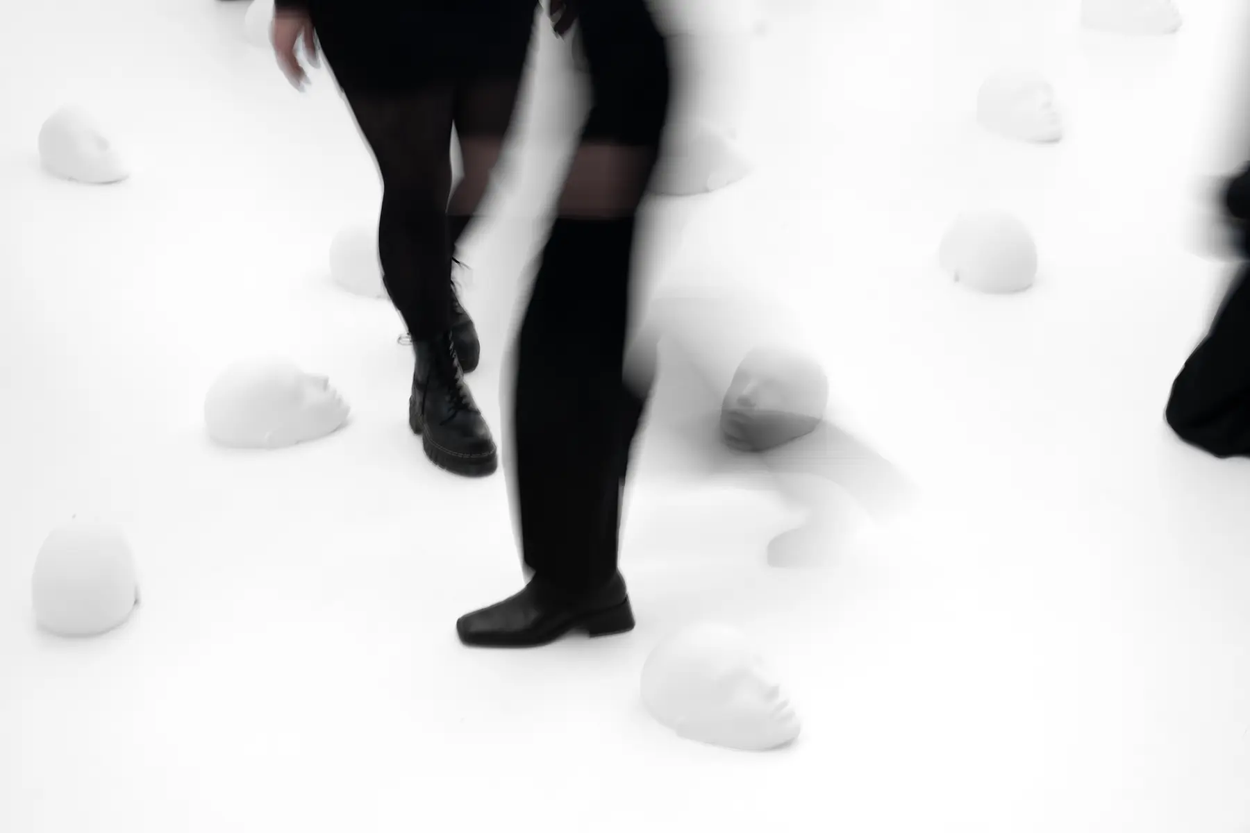View on sculptures spread around the room laying on the floor with people stepping over it from the project "Femicide" of the Visual Artist Irena Pejčić.