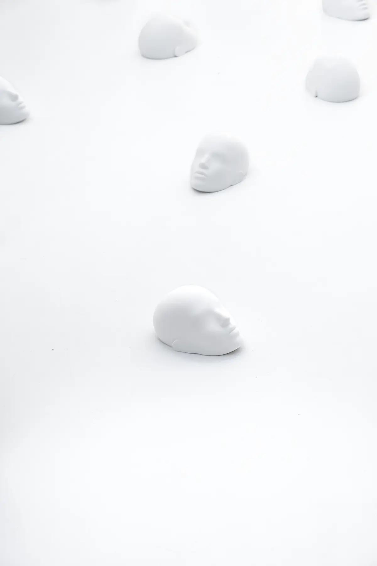 View on sculptures spread around the room laying on the floor with people stepping over it from the project "Femicide" of the Visual Artist Irena Pejčić.