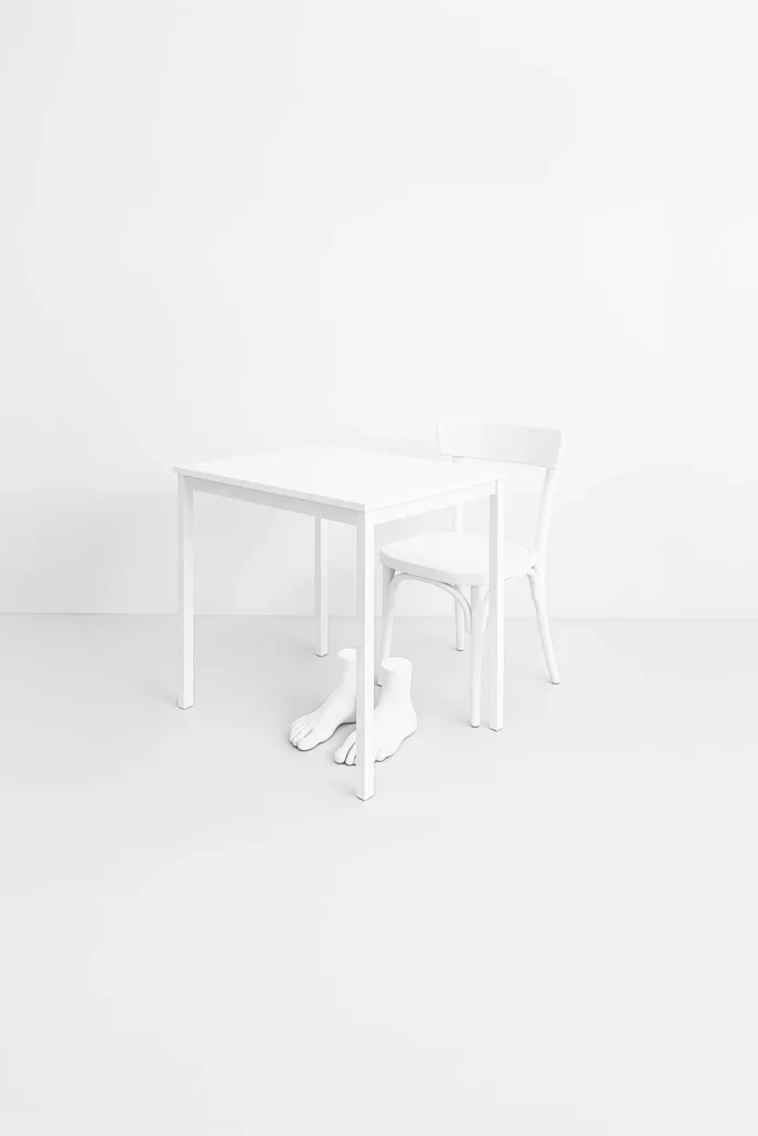 Table, a chair and a sculpture of feet.