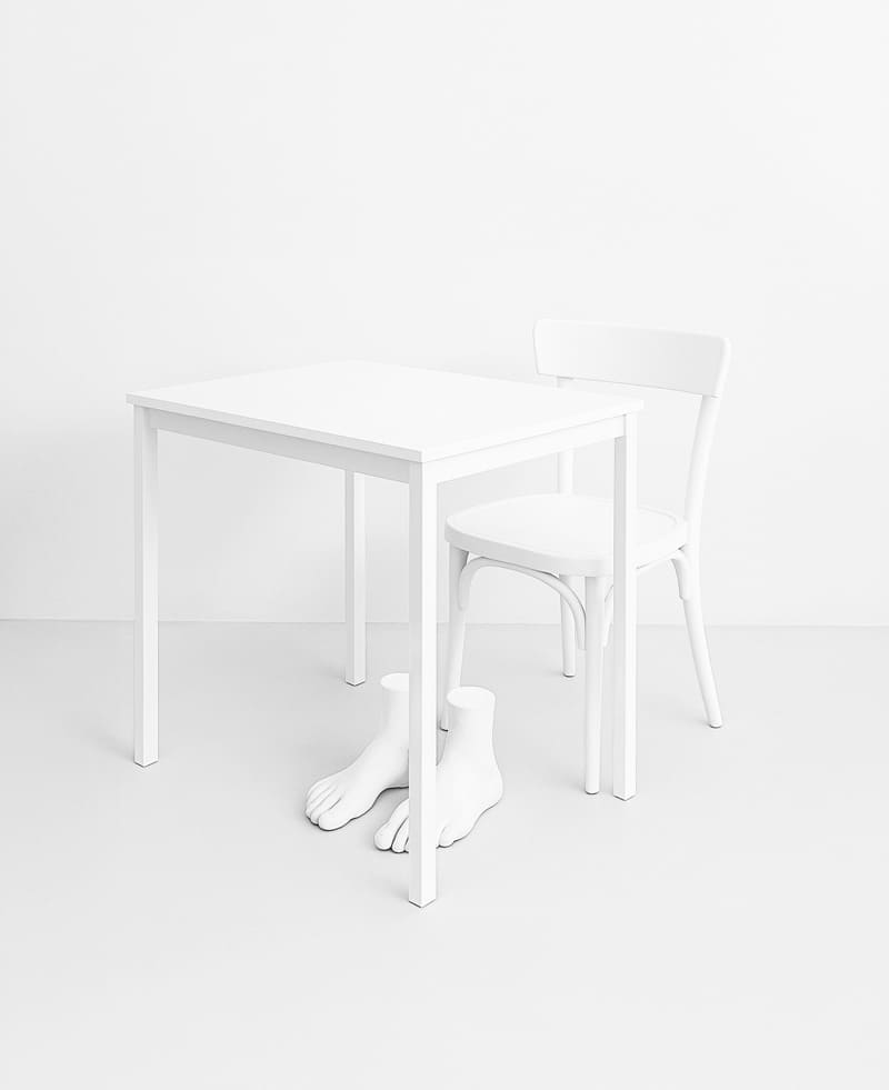 Table, a chair and a sculpture of feet.